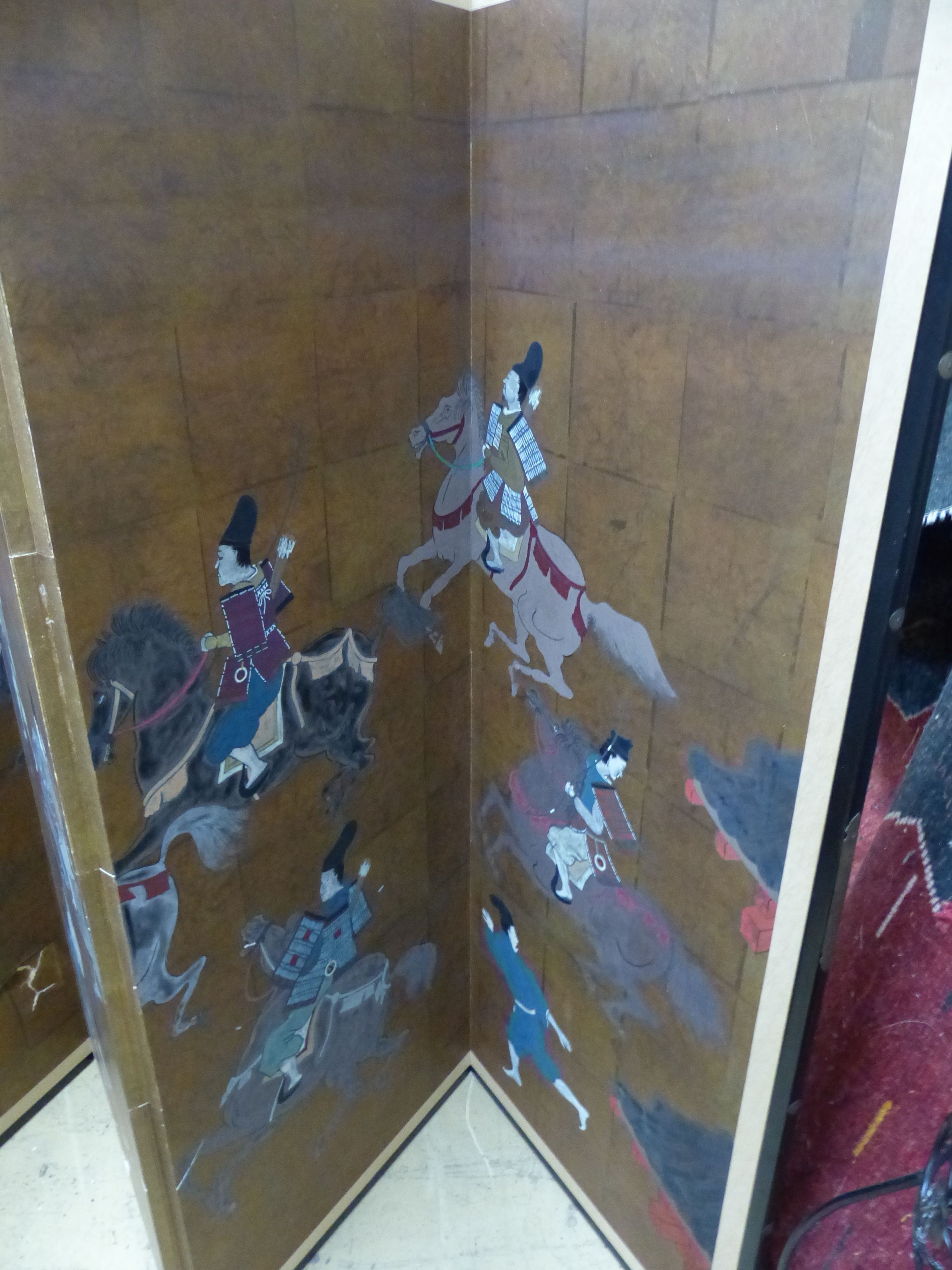 A Japanese four-fold screen, gold ground, decorated with warriors on horseback and foot, in black-lacquered and gilt metal round frame, each panel width 46cm height 122cm